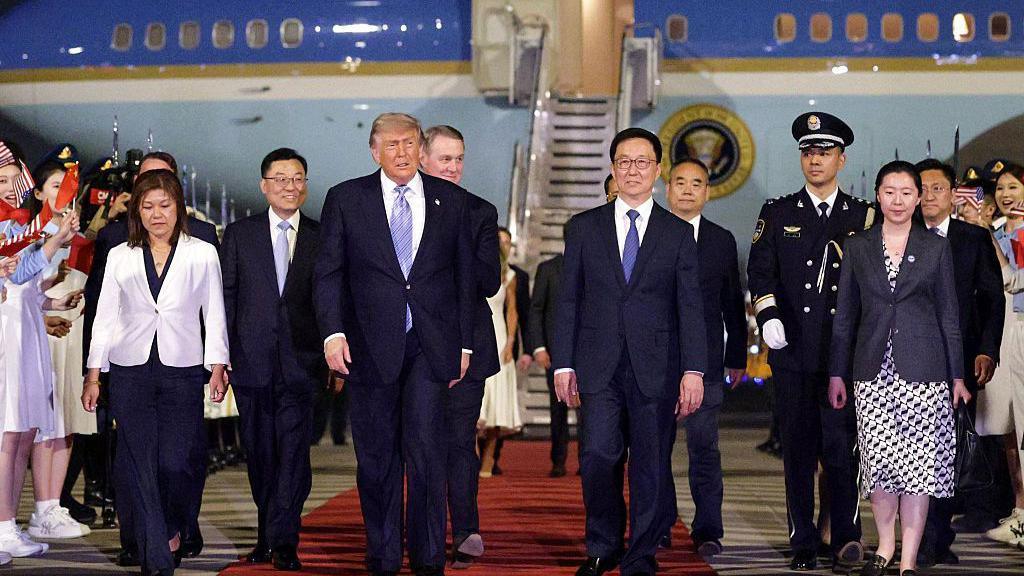 Donald Trump walking away from plane accompanied by Chinese Executive Vice Minister of Foreign Affairs Ma Zhaoxu, U.S. Ambassador to China David Perdue, Vice President of China Han Zheng and Chinese Ambassador to the U.S. Xie Feng