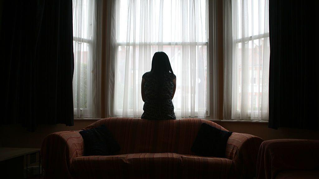 A woman in a darkened room. 