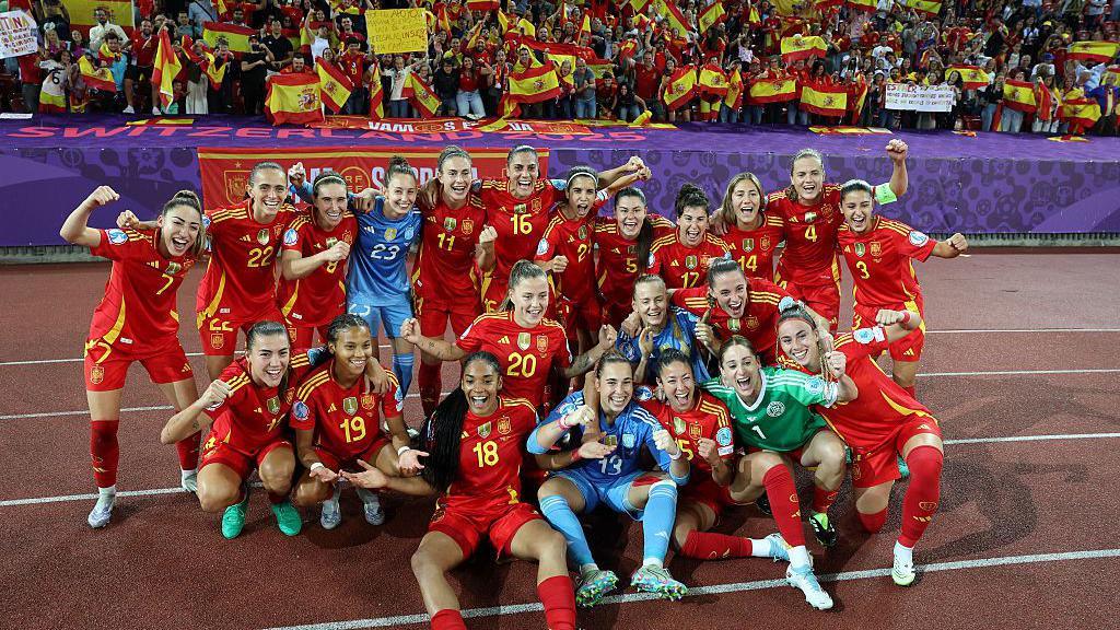 Spain's players pose for a photo following the team's semi-final victory against Germany.