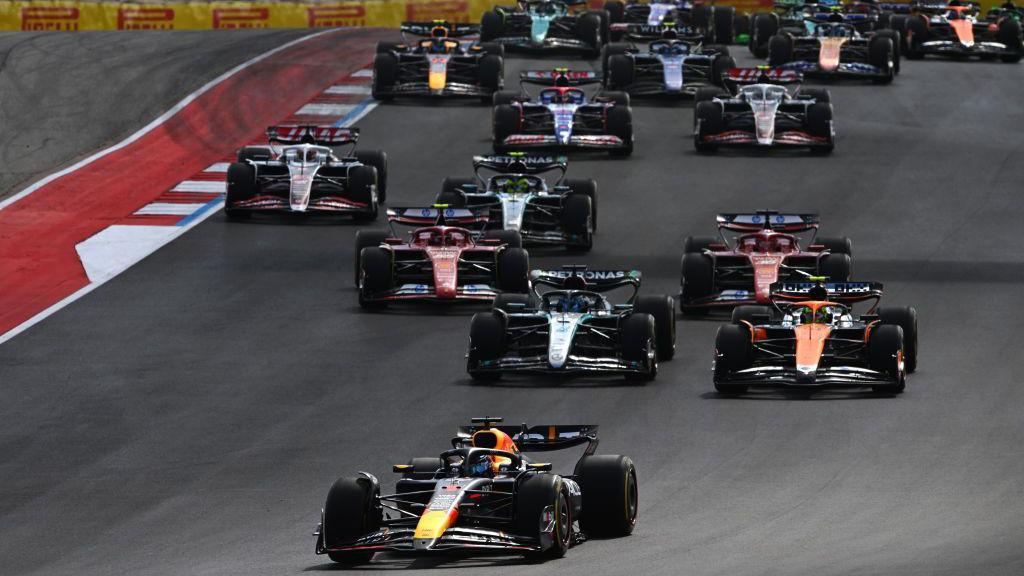 Lando Norris passes George Russell to take second place in the US Grand Prix sprint with the rest of the field behind them and Max Verstappen leading