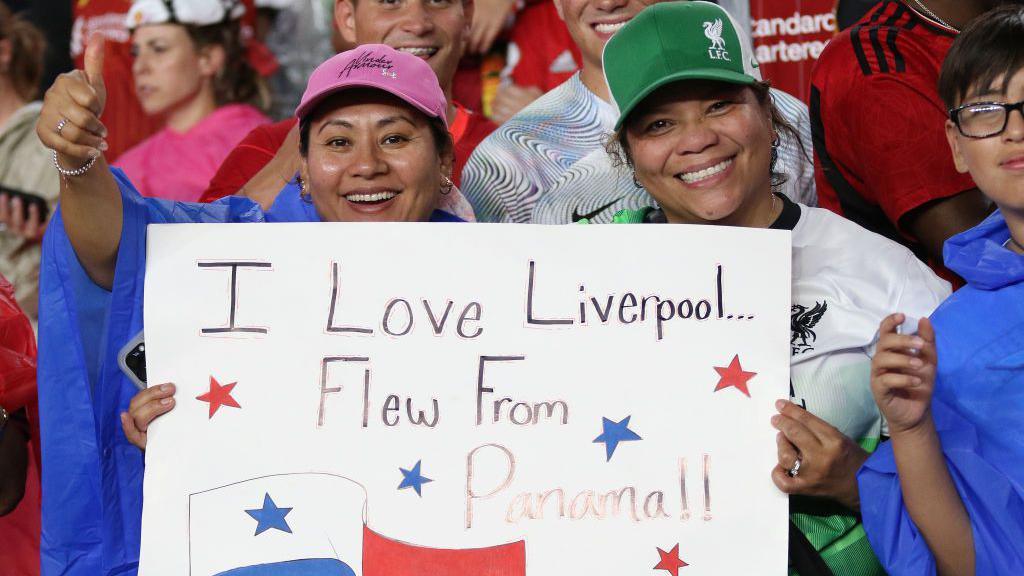 Fans hold up a sign during Liverpool's pre-season game with Manchester United