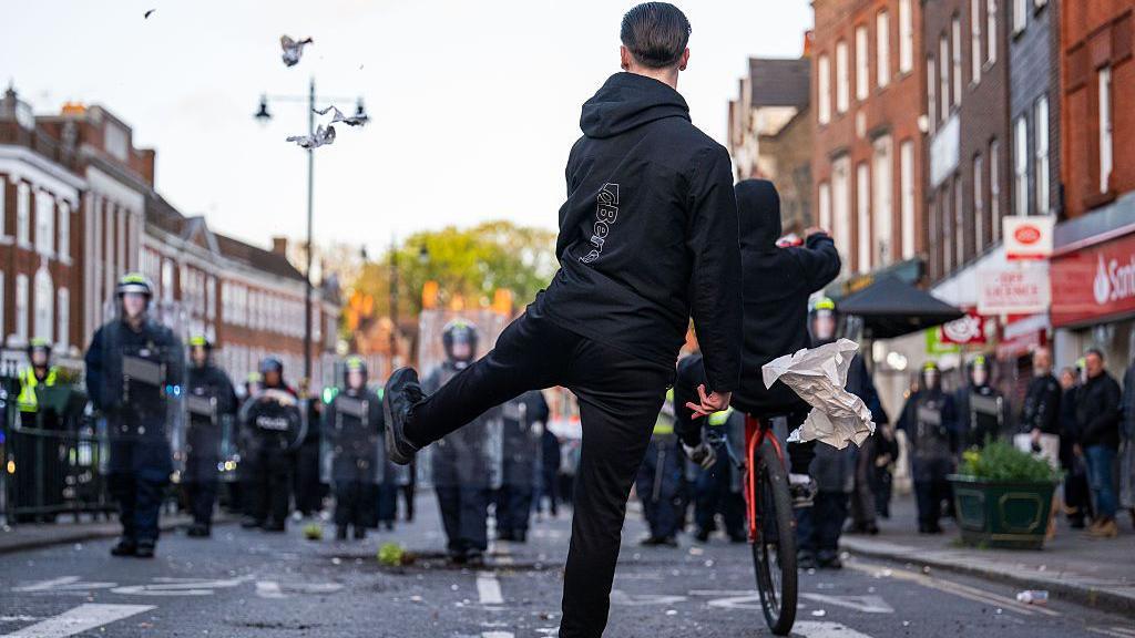 Police are seen on Epsom high street as people come out to protest after a woman was raped last Saturday on April 15, 2026 in Epsom.