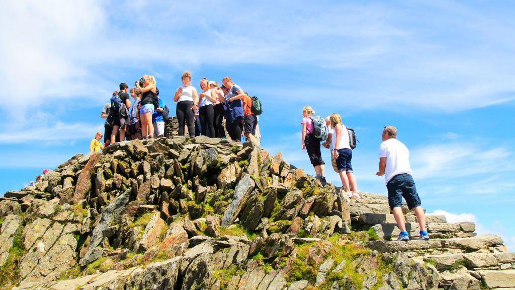 Walkers at the summit of Yr Wyddfa on a hot summer's day