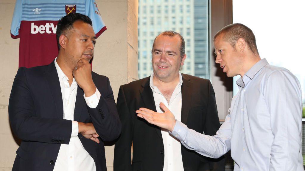 Karim Virani (l) speaks at a partner meeting during his first stint at the club