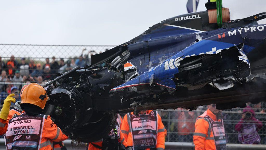 Logan Sargeant's damaged car is lifting on to the recovery truck 