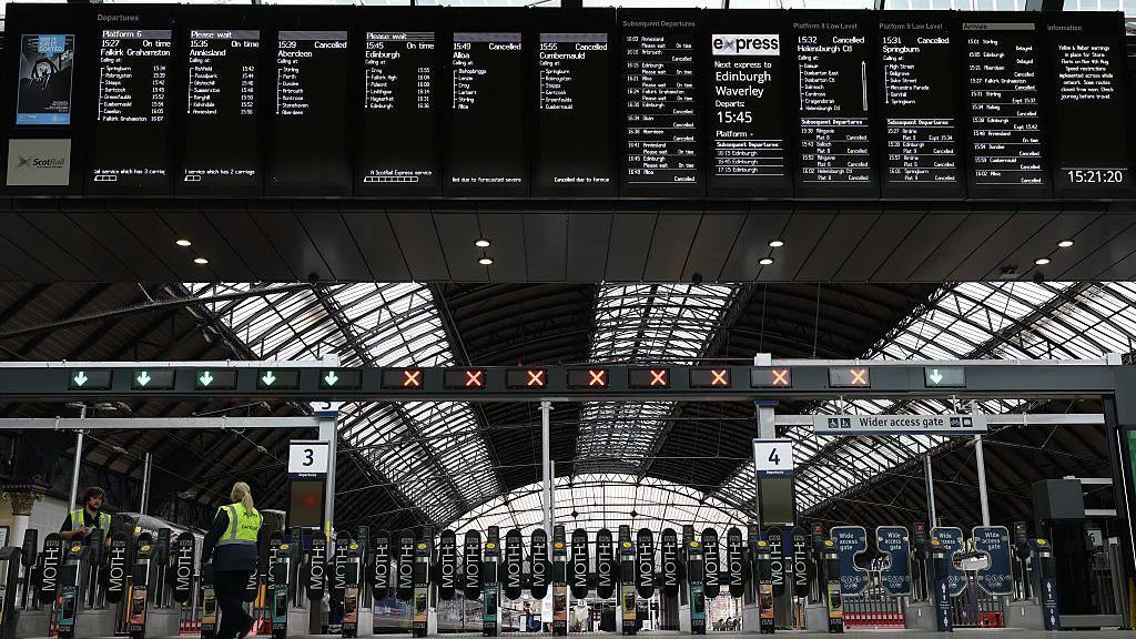 Signs showing cancelled trains are displayed at Queen Street station in Glasgow, Scotland.