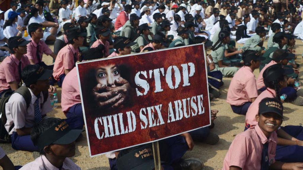 Indian school students participate in an awareness Campaign against Child Sex Abuse (CSA) in Hyderabad on November 19, 2014, the World Day for Prevention of Child Abuse. One of them holds a "STOP CHILD SEX ABUSE" banner. 