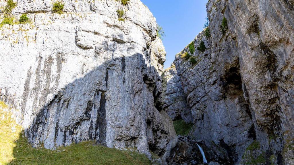 A limestone gorge with twin rock faces split by a ravine.