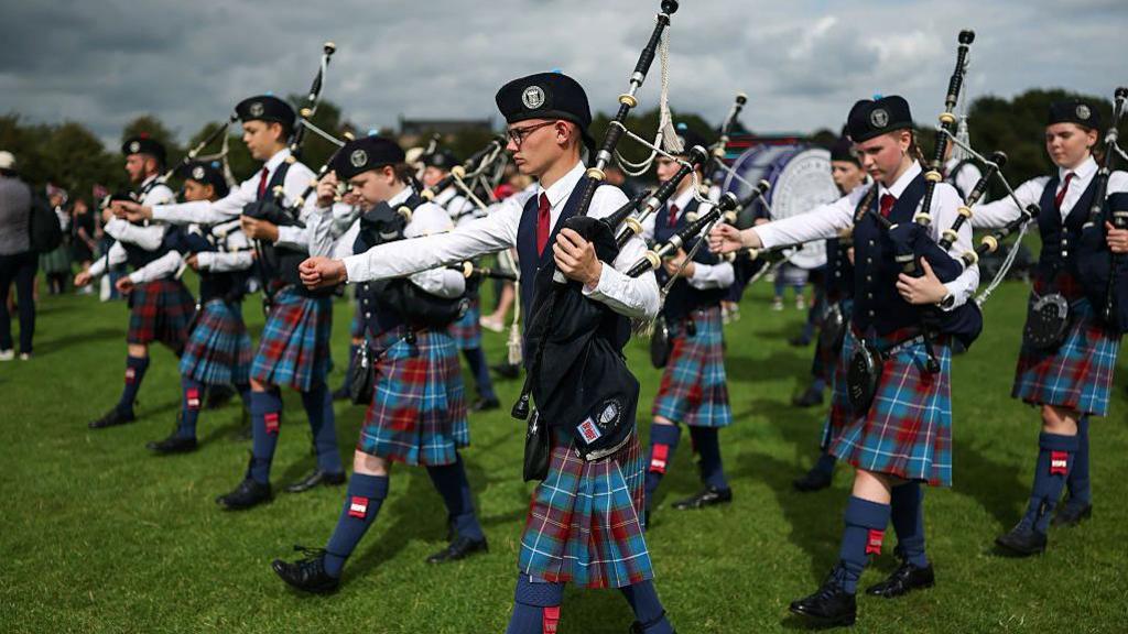 Young pipe band members marching