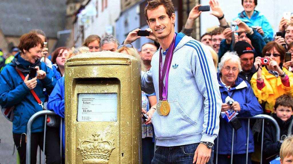 Gold post box with Andy Murray standing next to it