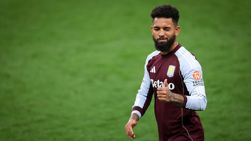 Douglas Luiz gives a thumbs-up while playing for Aston Villa
