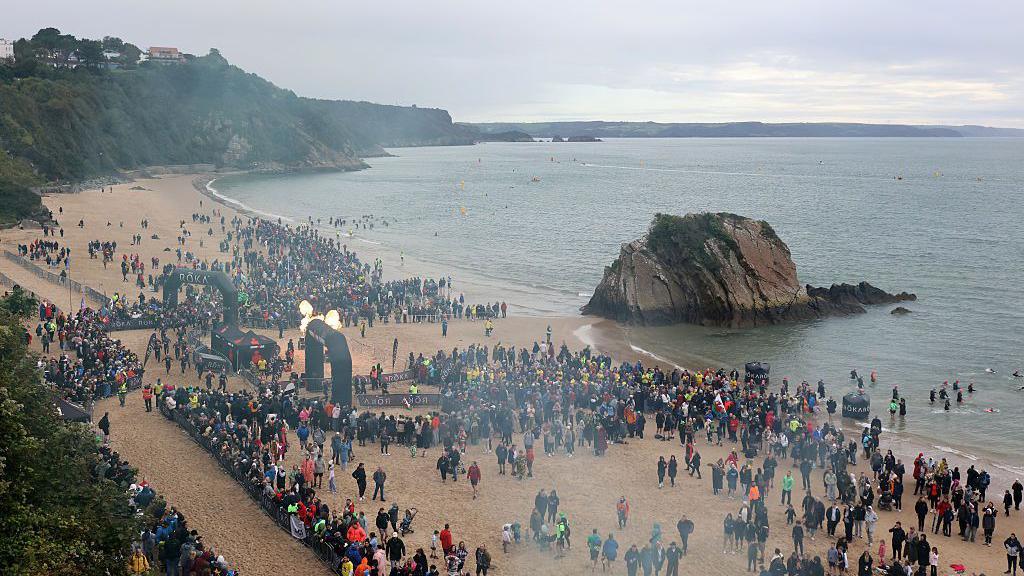 Crowds gather on Tenby's North Beach for the start of Ironman Wales
