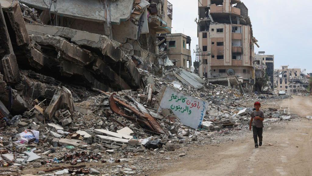 A Palestinian boy walks past rubble in Gaza on 1 September, 2024