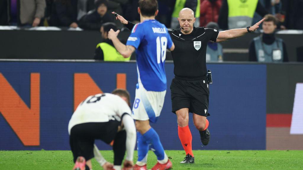 The referee overturns a penalty decision during Italy's game with Germany