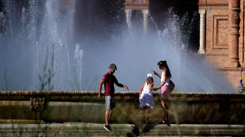 family by water fountain. 