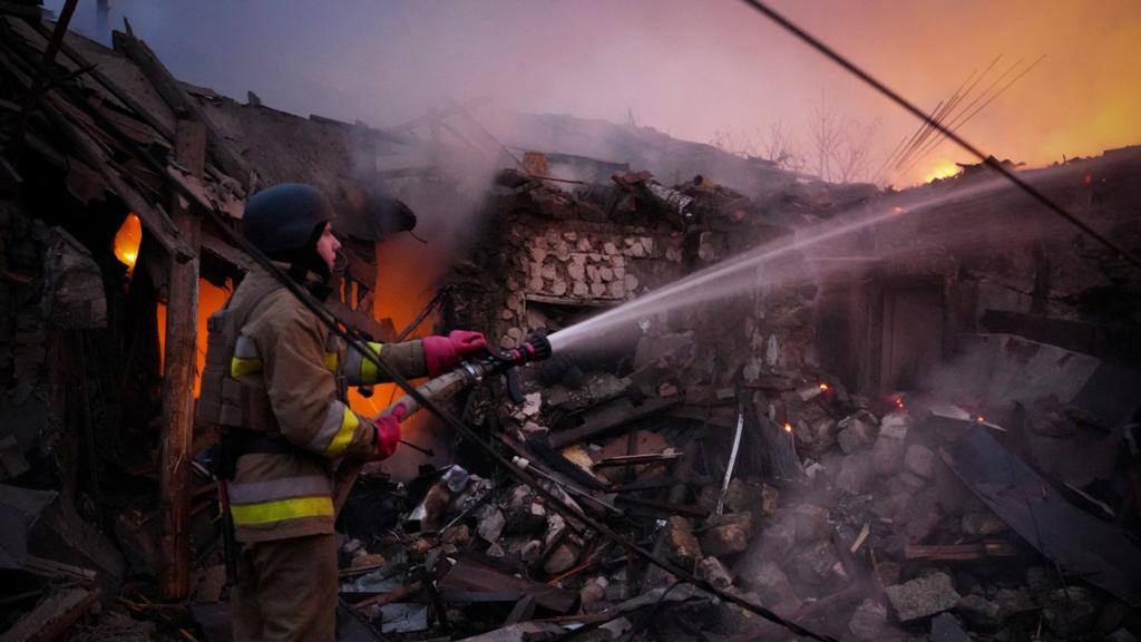 A firefighter works at the site of a residential house hit by a Russian drone strike in Mykolaiv