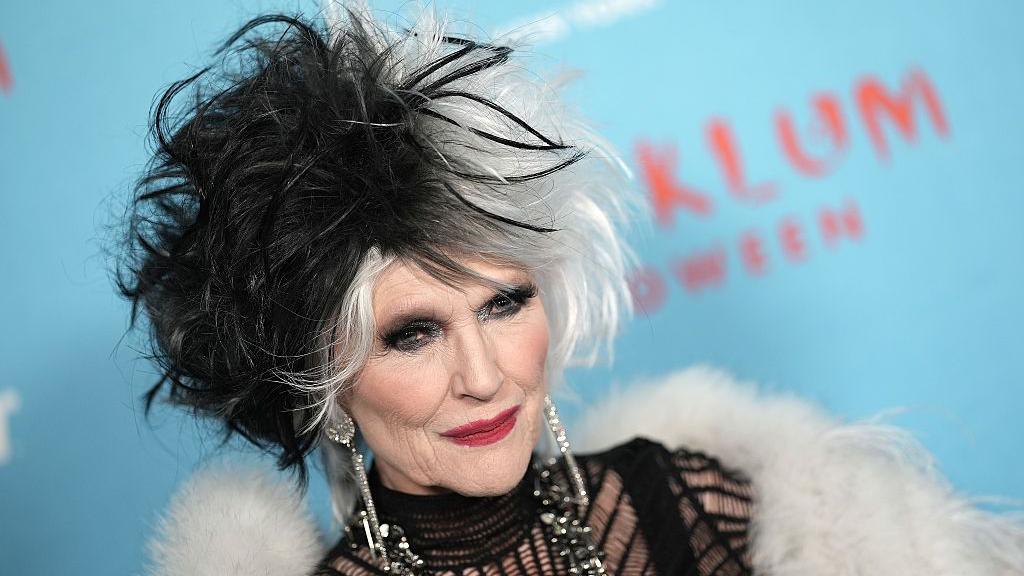 Musk with hair dyed black and white, and a white shawl