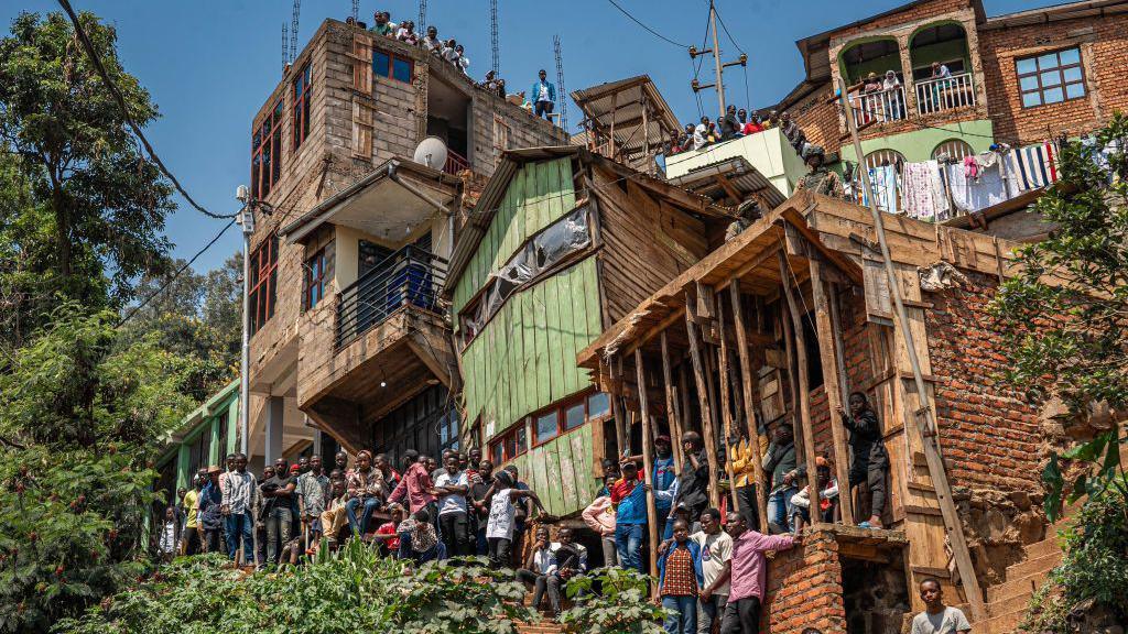 Residents stand by a collection of picturesque houses that are squeezed together on an incline in Bukavu, DR Congo - Thursday 27 February 2025.