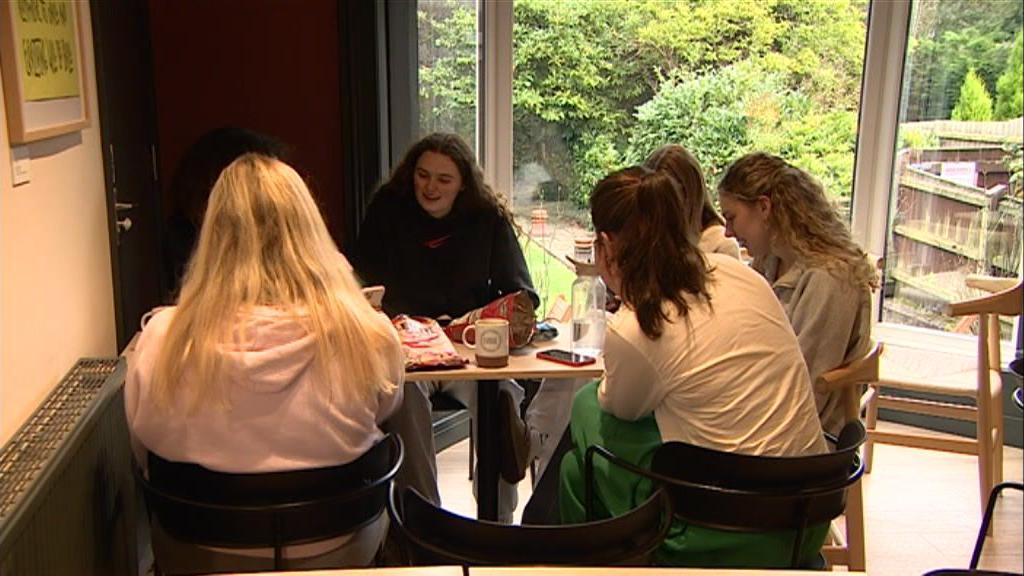 A photo of a group of friends sitting inside the Grounded cafe chatting and socialising