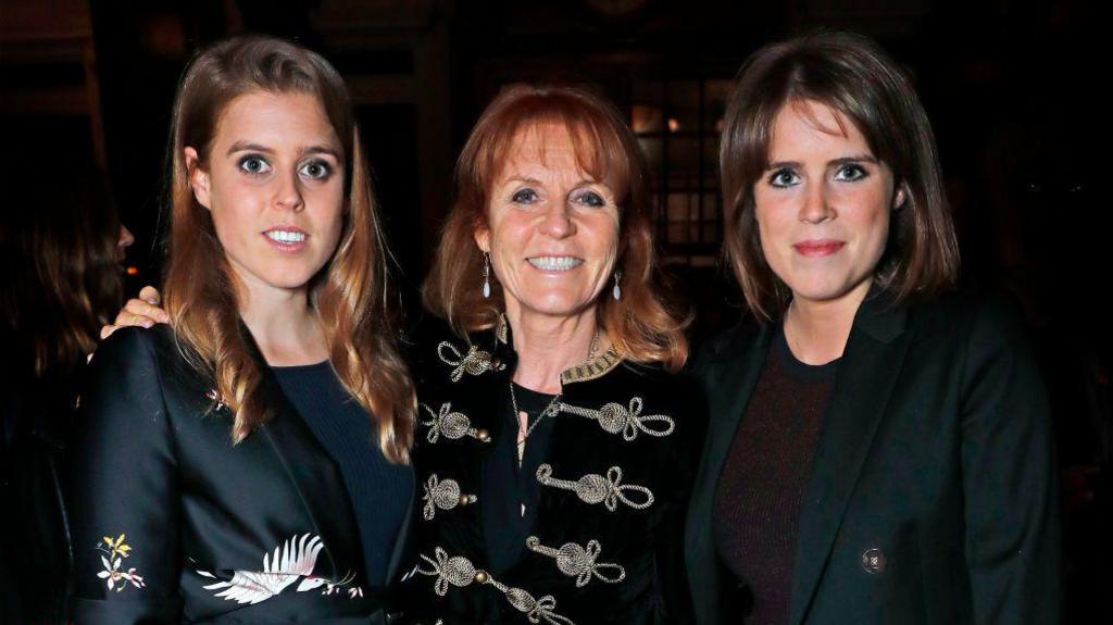 Princesha Beatrice e Jorkut, Sarah Ferguson, atëherë Dukesha e Jorkut dhe Princesha Eugenie e Jorkut, të gjitha të veshura me të zeza në një event lançimi.