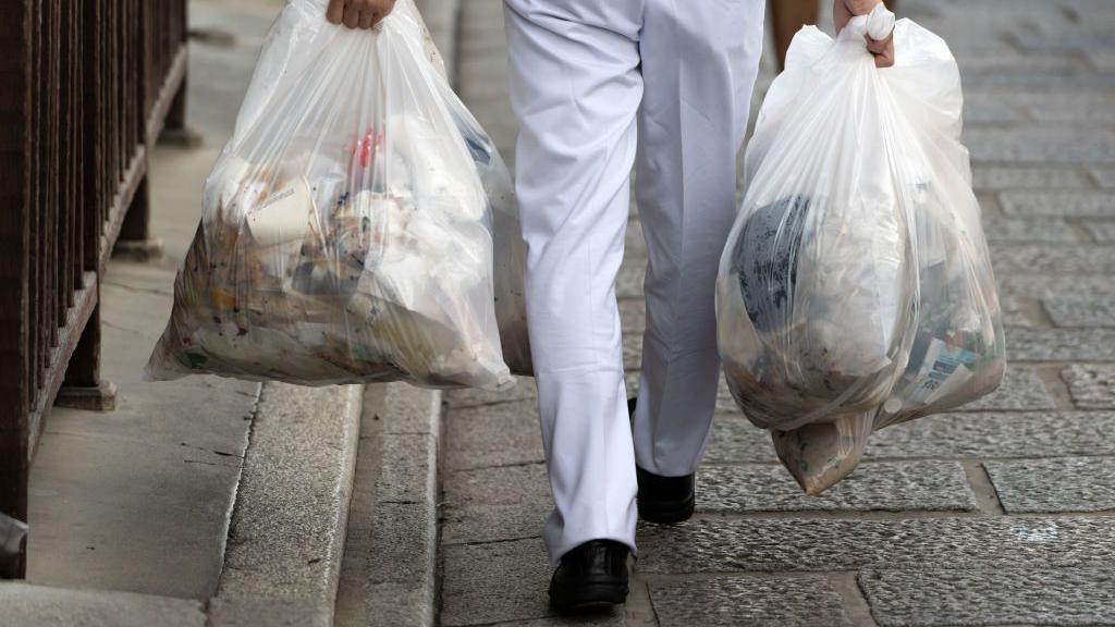 A man carrying rubbish bags 