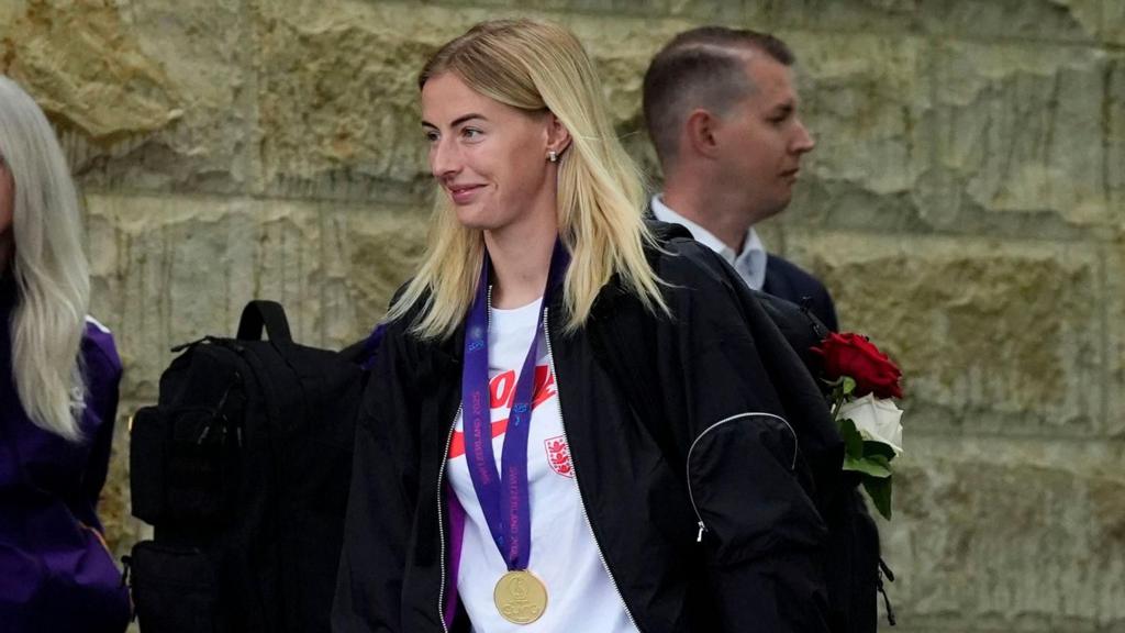 Chloe Kelly boarding the team bus with her winners' medal round her neck.