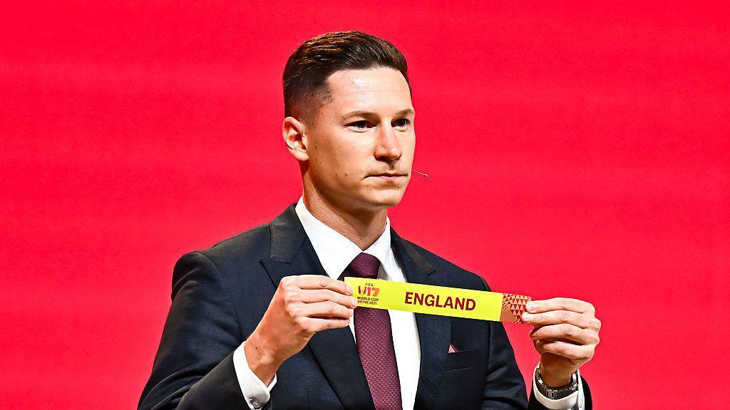 Julian Draxler holding a piece of paper that says England