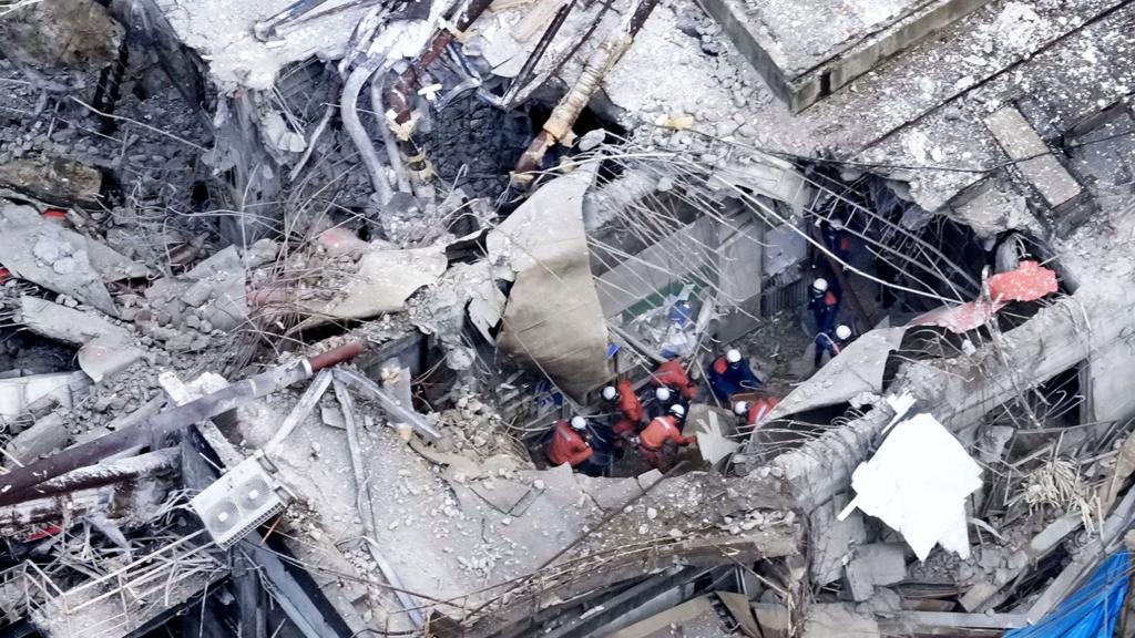 An aerial view shows emergency responders searching rubble at Nippon paper factory in Yatsushiro on Wednesday.