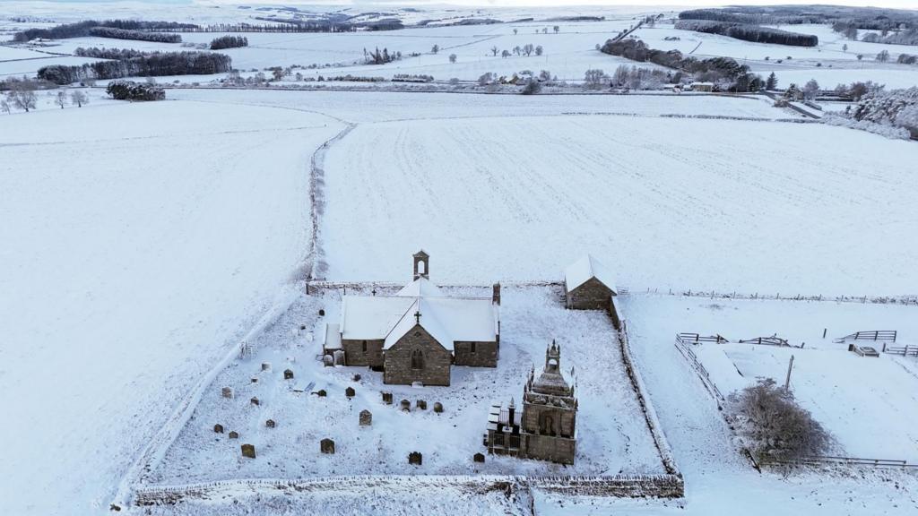 Aerial view of church in field of snow