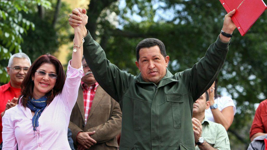 Venezuelan President Hugo Chavez (R) holds up the minutes of the constitutional amendment handed in by the president of the National Assembly Cilia Flores (L).