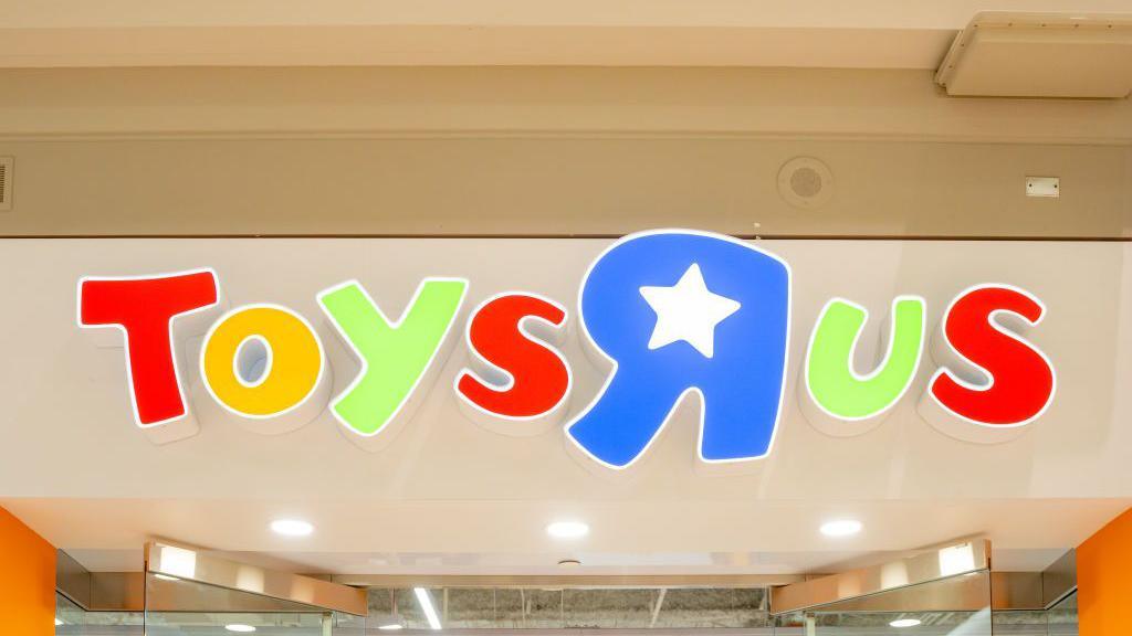 A multi-coloured Toys R Us  sign above the entrance to a store. 