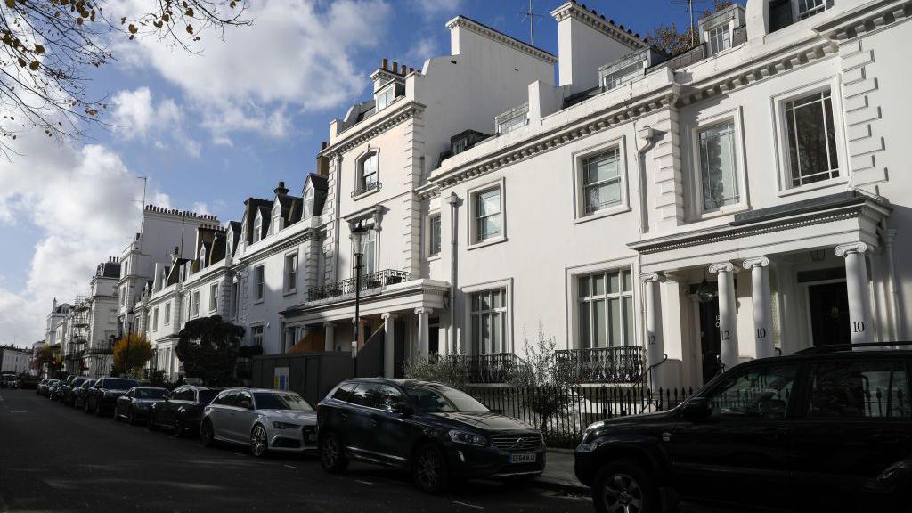 The home of Zamira Hajiyeva, on Walton Street, Knightsbridge, a smart, white townhouse on an expensive London street, with cars parked along the side of the pavement.
