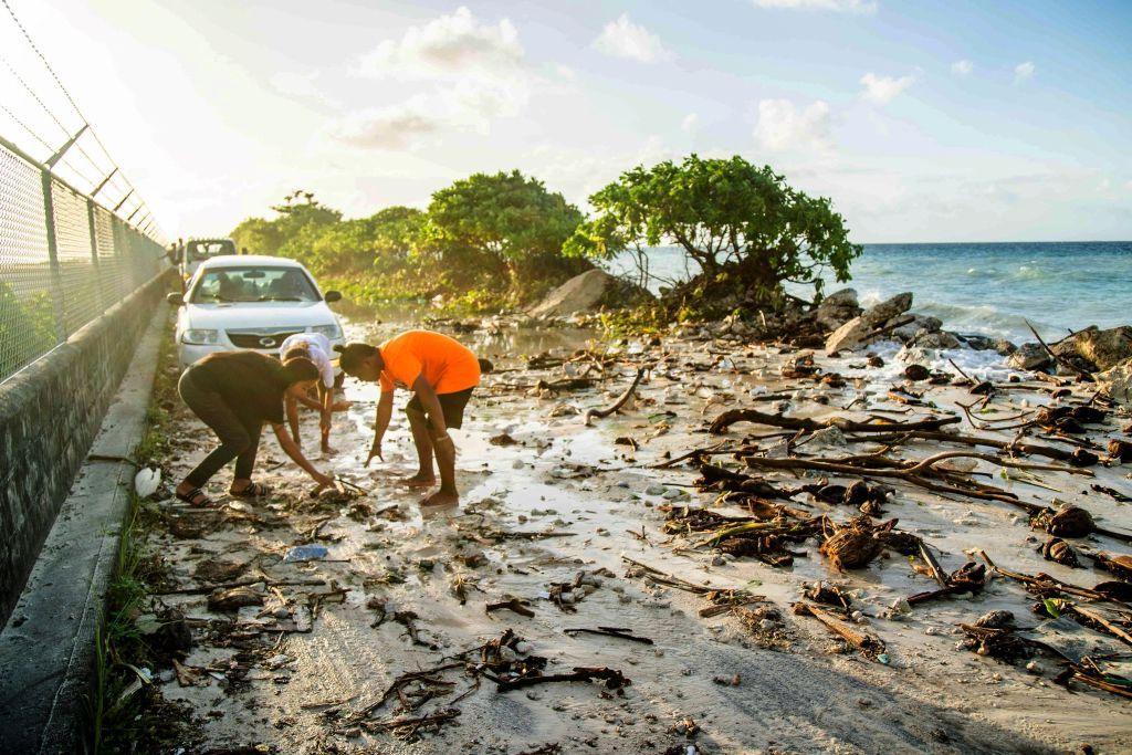 People clean up a flooded beach