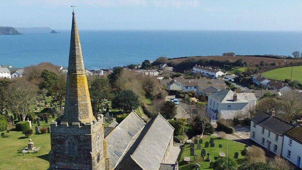 A drone photograph of the Spire on top of the church overlooking Gerrans Bay