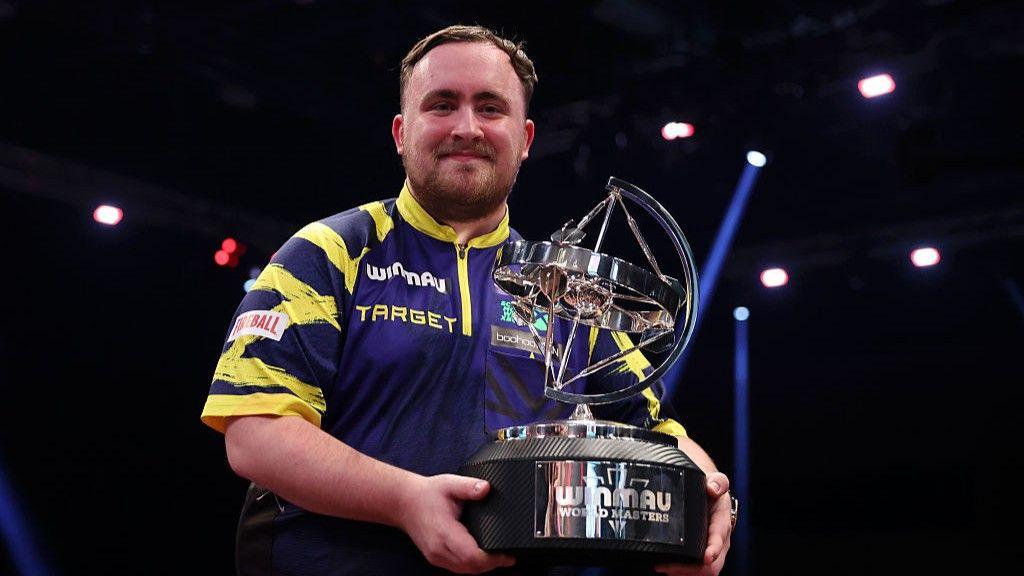 Luke Littler holding the World Matchplay Darts trophy