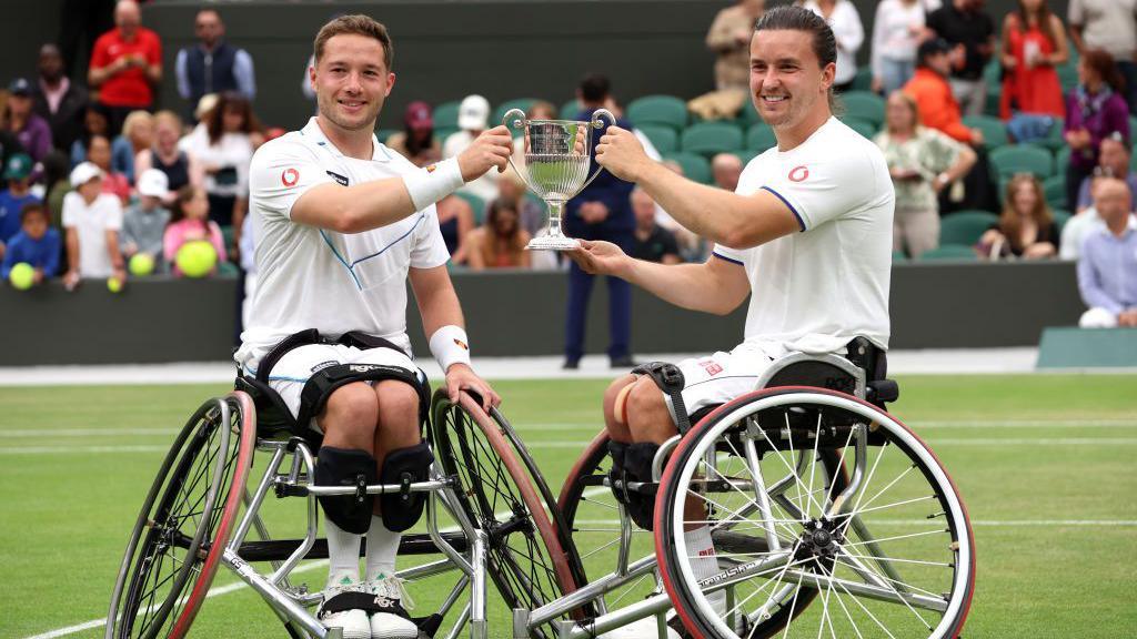 Alfie Hewett and Gordon Reid lift the wheelchair men's doubles trophy