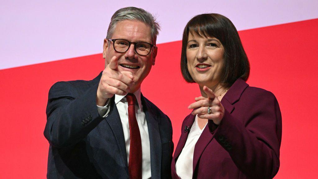 Britain's Prime Minister Keir Starmer (L) and Britain's Chancellor of the Exchequer Rachel Reeves (R) smile and point to the audience after Reeves delivers her speech on the second day of the annual Labour Party conference in Liverpool. 