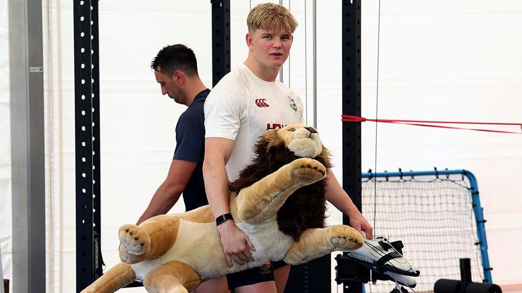 Henry Pollock holds the Lions mascot Bil