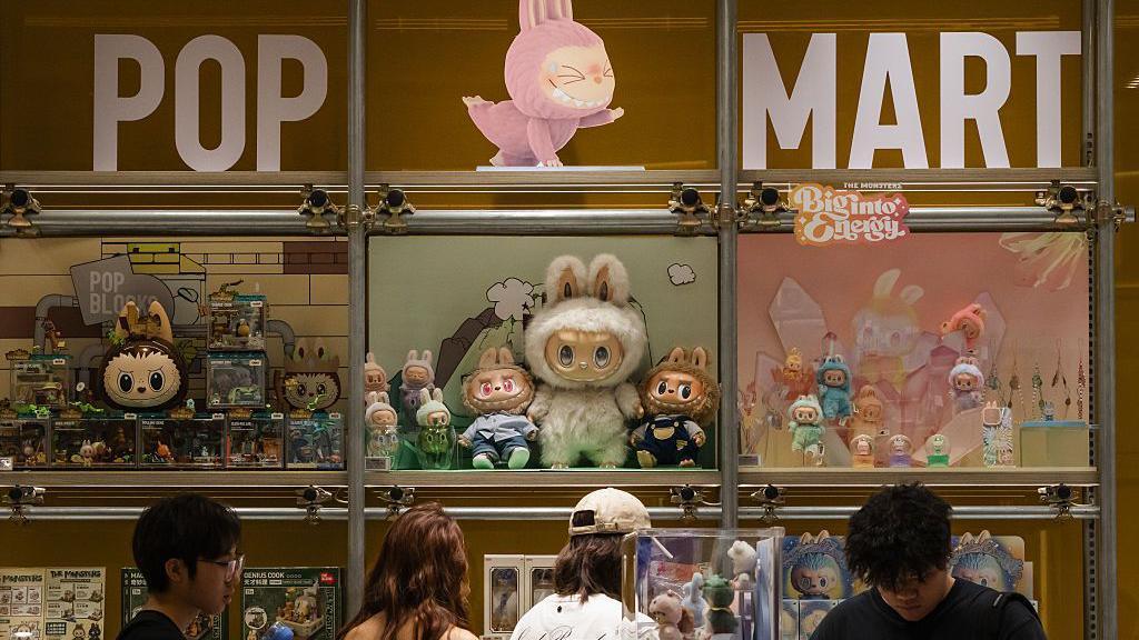 Customers browse a Pop Mart display filled with Labubu characters and collectible figures from The Monsters series on June 16, 2025 in Chongqing, China.