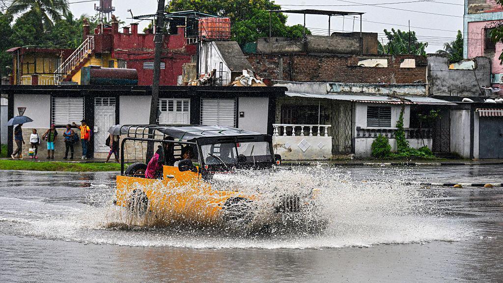 Car driving through rain in Cuba.
