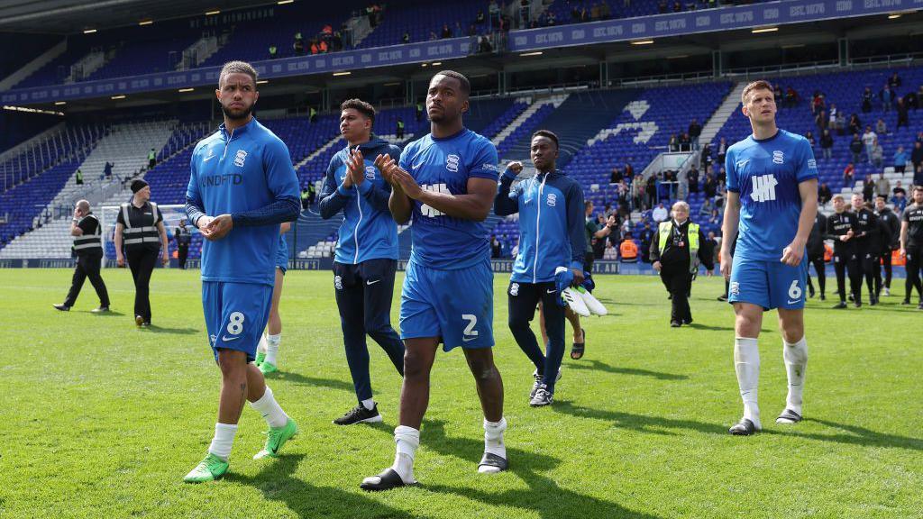 Birmingham City players walk along the turf and applaud fans at St Andrew's