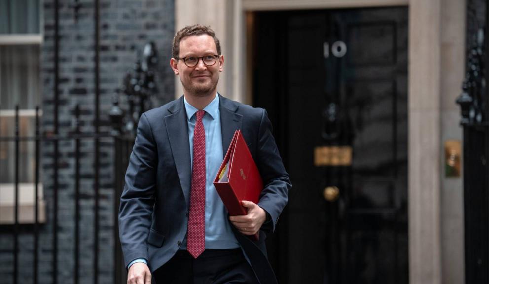 Darren Jones walks with a red binder in front of No 10.