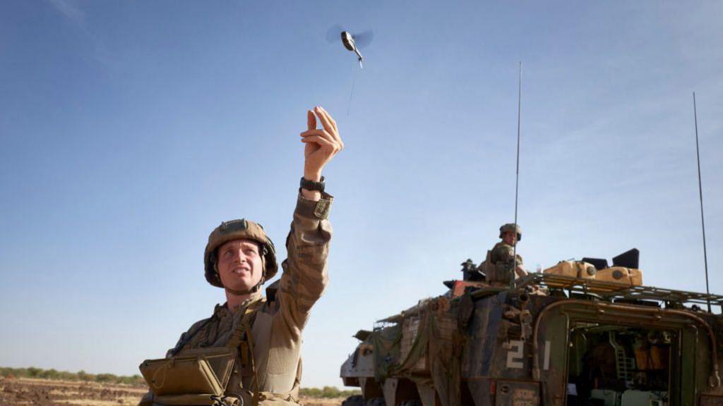 A soldier of the French Army launches a mini-drone used to check the presence of jihadist groups within a radius of 2 kilometers, during the Bourgou IV operation, in northern Burkina Faso, on November 11, 2019