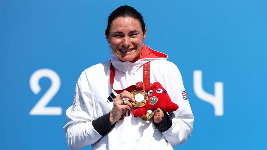 Sarah Storey smiles while holding her gold medal