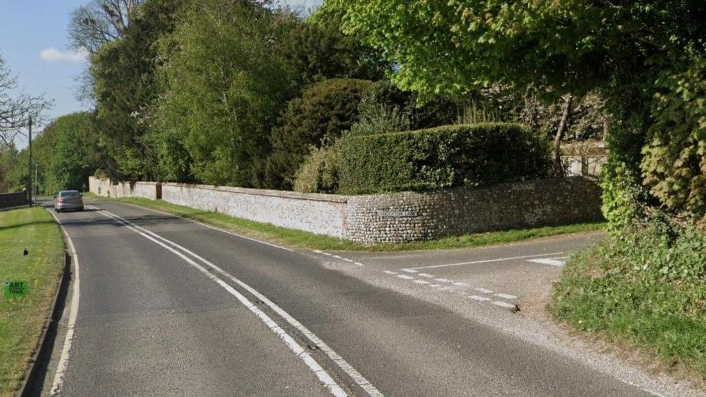 A Google Maps image showing a t-junction on an A road in Sussex with a flint stone wall encasing a property on the corner of the junction