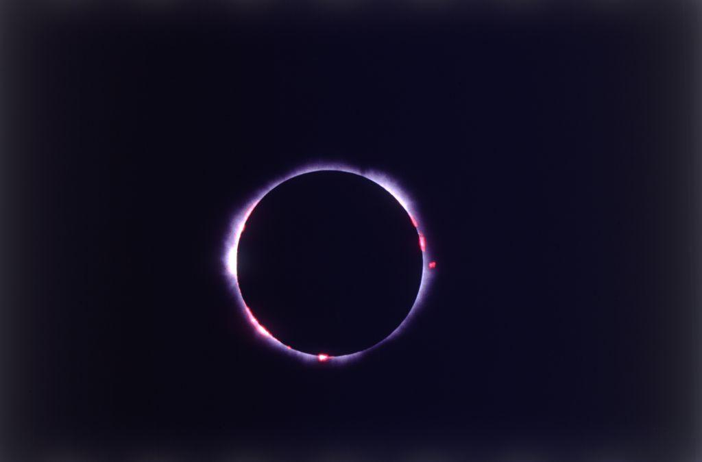 The corona of the sun visible around the moon during a total solar eclipse.