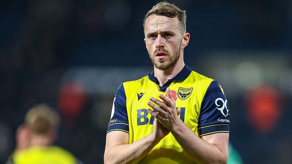 Oxford United defender Sam Long applauds the fans after a game