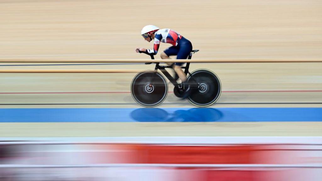 Sarah Storey cycling with the background of the track blurred