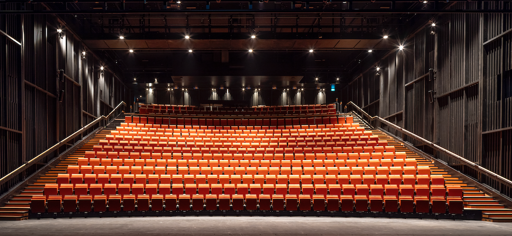 The new auditorium is pictured comprising of 550 orange seats with steps alongside them and spotlights up above