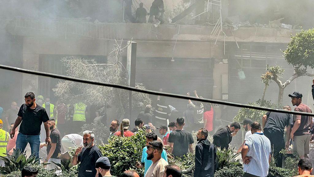 People look for survivors at the site of an Israeli airstrike that targeted a building in Beirut's southern suburbs on June 14, 2026. T